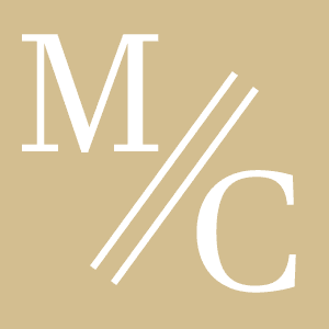 White capital letters "M" and "C" are separated by two diagonal lines on a tan square background.